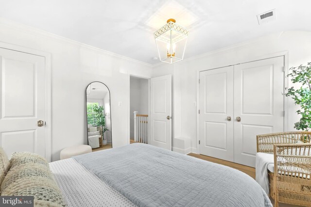 2402 E Randolph Ave, Alexandria, VA 22301 - bedroom featuring a chandelier, wood finished floors, a closet, and crown molding