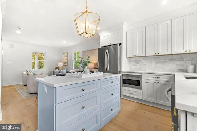 2402 E Randolph Ave, Alexandria, VA 22301 - kitchen featuring recessed lighting, decorative backsplash, open floor plan, a kitchen island, and white cabinetry