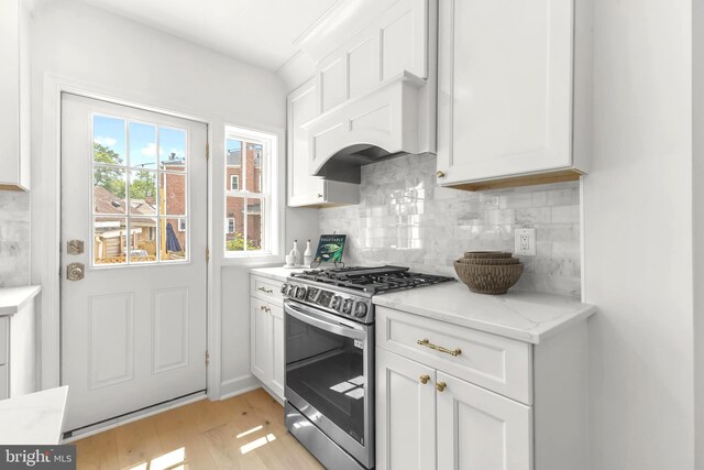 2402 E Randolph Ave, Alexandria, VA 22301 - kitchen featuring stainless steel gas range, white cabinetry, backsplash, light wood-type flooring, and light stone counters