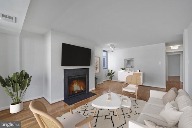 1140 23rd St NW Unit 903, Washington, DC 20037 - living area featuring wood finished floors, a fireplace with flush hearth, and baseboards