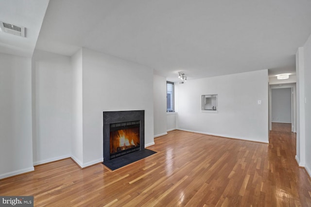 1140 23rd St NW Unit 903, Washington, DC 20037 - unfurnished living room with wood finished floors, a fireplace with flush hearth, and baseboards