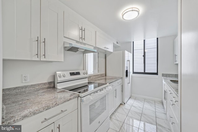 1140 23rd St NW Unit 903, Washington, DC 20037 - kitchen with white appliances, under cabinet range hood, light marble finish flooring, white cabinetry, and baseboards