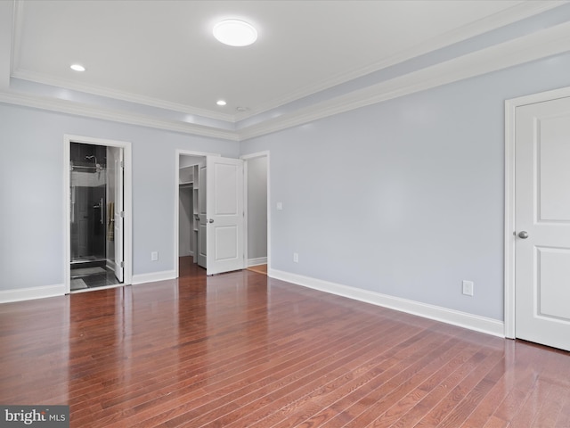 8211 Hocking Pl, Alexandria, VA 22309 - unfurnished bedroom with a tray ceiling, crown molding, a walk in closet, wood finished floors, and baseboards