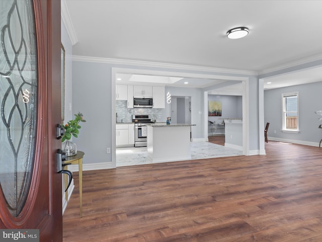 8211 Hocking Pl, Alexandria, VA 22309 - kitchen with stainless steel appliances, crown molding, white cabinetry, baseboards, and wood finished floors