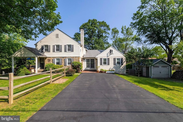 1864 Edge Hill Rd, Abington, PA 19001 - view of front of property featuring asphalt driveway, stone siding, a front yard, an outbuilding, and a chimney