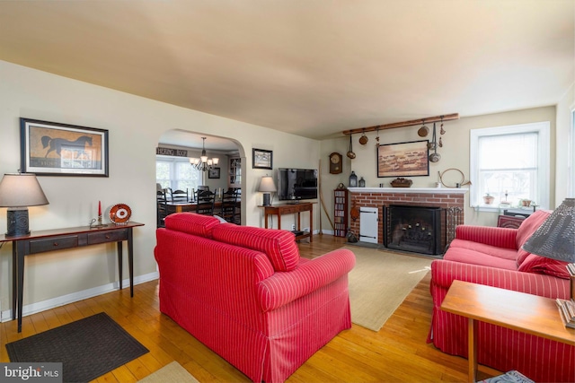 1864 Edge Hill Rd, Abington, PA 19001 - living room featuring arched walkways, hardwood / wood-style floors, a chandelier, a fireplace, and baseboards