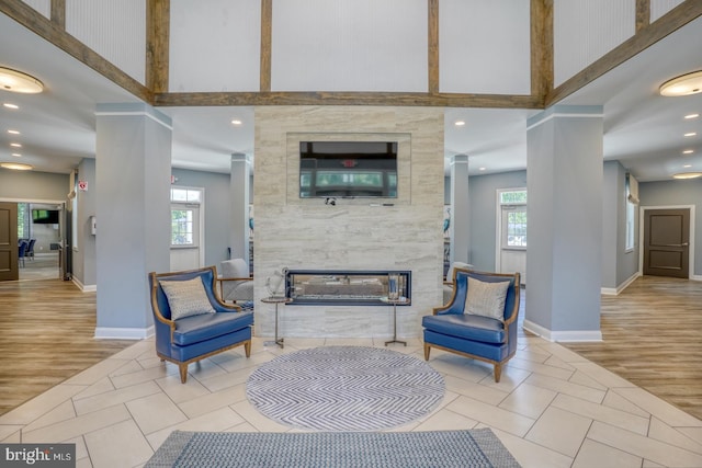 18208 Emerson Way, Georgetown, DE 19947 - living area with ornate columns, a towering ceiling, a premium fireplace, wood finished floors, and recessed lighting