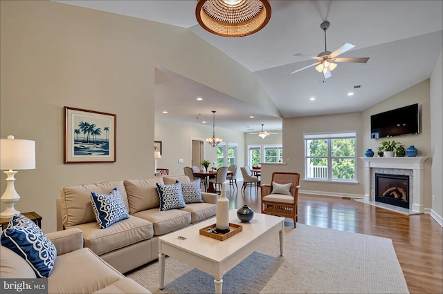 18208 Emerson Way, Georgetown, DE 19947 - living room with ceiling fan, wood finished floors, lofted ceiling, a glass covered fireplace, and recessed lighting