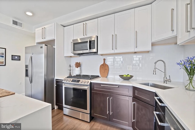525 Kennedy St NW Unit 4, Washington, DC 20011 - kitchen featuring appliances with stainless steel finishes, a sink, light countertops, white cabinetry, and light wood-type flooring