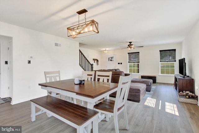 2536 Stoverstown Rd, Spring Grove, PA 17362 - dining area featuring a chandelier, wood finished floors, stairway, baseboards, and a ceiling fan