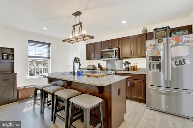2536 Stoverstown Rd, Spring Grove, PA 17362 - kitchen with appliances with stainless steel finishes, light wood-style floors, an island with sink, light stone counters, and recessed lighting