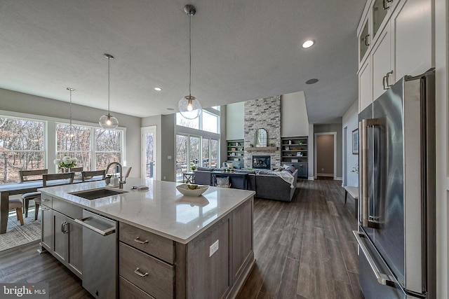 547 Webb Rd # Ad, Chadds Ford, PA 19317 - kitchen with stainless steel appliances, a sink, a stone fireplace, a kitchen island with sink, and dark wood-type flooring