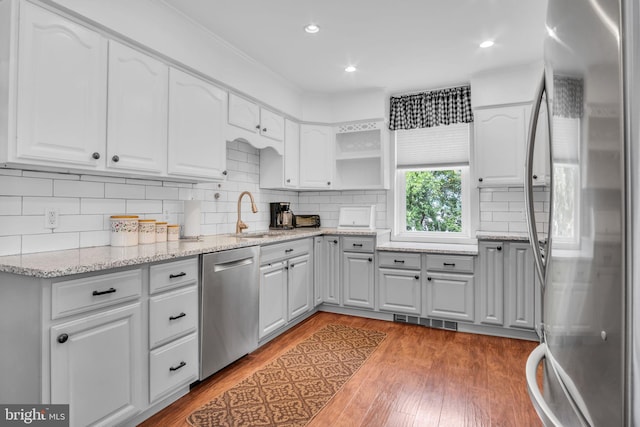 1749 Carrolls Tract Rd, Orrtanna, PA 17353 - kitchen featuring appliances with stainless steel finishes, a sink, light wood finished floors, white cabinetry, and light stone counters