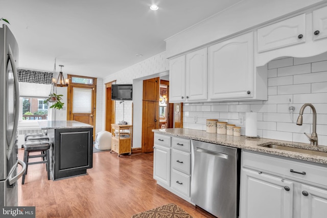 1749 Carrolls Tract Rd, Orrtanna, PA 17353 - kitchen featuring stainless steel appliances, a sink, white cabinets, decorative backsplash, and light stone counters