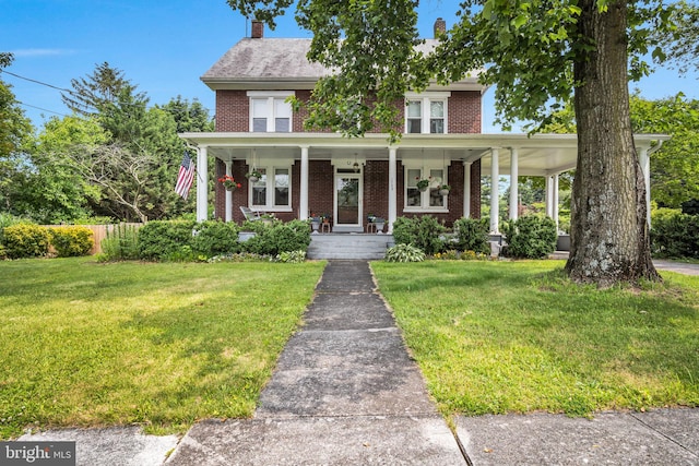 1749 Carrolls Tract Rd, Orrtanna, PA 17353 - view of front facade with brick siding, a front lawn, a porch, and a chimney