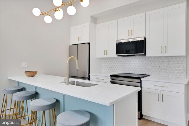 4019 9th St NE Unit 3, Washington, DC 20017 - kitchen featuring stainless steel appliances, a kitchen bar, backsplash, white cabinetry, and light countertops
