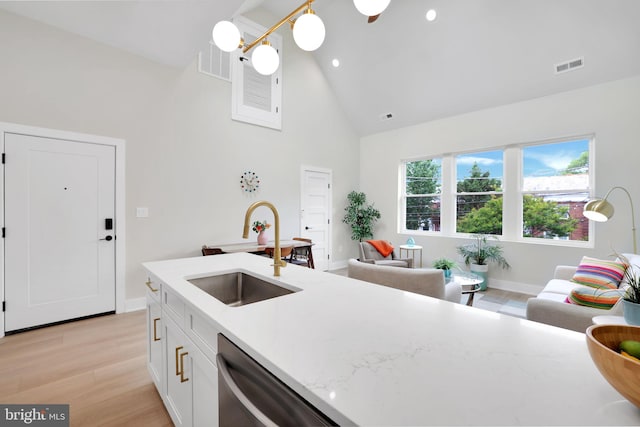 4019 9th St NE Unit 3, Washington, DC 20017 - kitchen with a sink, stainless steel dishwasher, high vaulted ceiling, light wood finished floors, and white cabinets