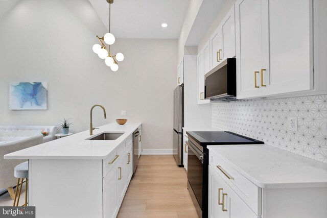 4019 9th St NE Unit 3, Washington, DC 20017 - kitchen with stainless steel appliances, a sink, a peninsula, a kitchen breakfast bar, and decorative backsplash