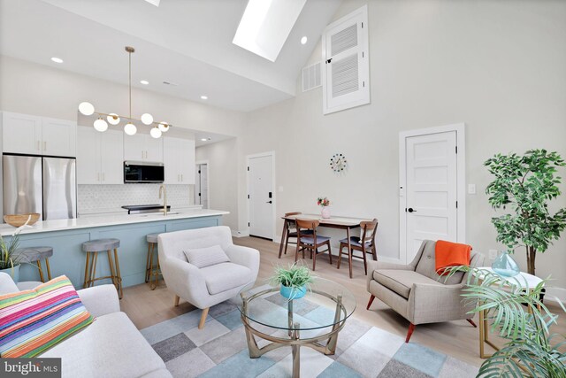 4019 9th St NE Unit 3, Washington, DC 20017 - living room with high vaulted ceiling, a skylight, light wood-style floors, and recessed lighting