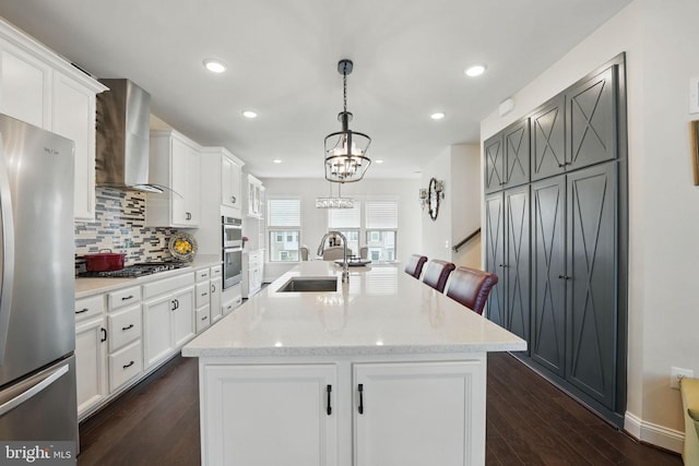 2069 Alder Ln, Dumfries, VA 22026 - kitchen with a sink, wall chimney range hood, stainless steel appliances, decorative backsplash, and white cabinetry