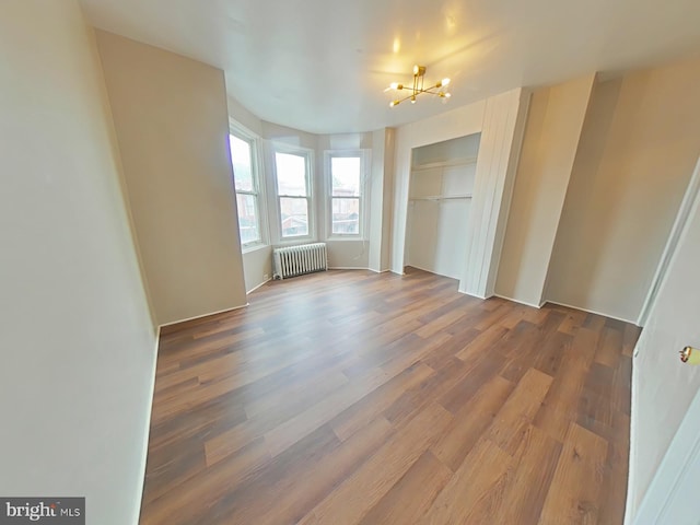 4019 N Marshall St, Philadelphia, PA 19140 - unfurnished bedroom featuring radiator heating unit, wood finished floors, a chandelier, and a closet