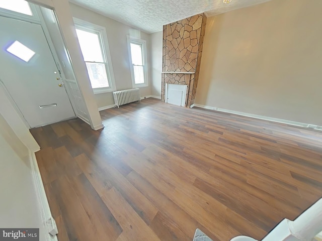 4019 N Marshall St, Philadelphia, PA 19140 - foyer entrance featuring radiator, wood finished floors, and a stone fireplace