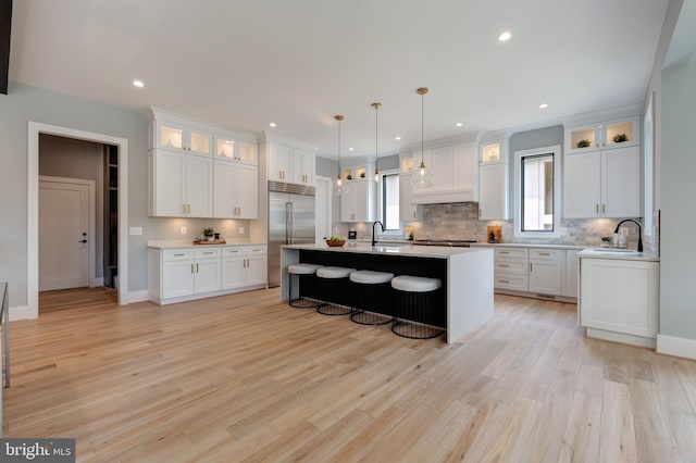 6800 Old Chesterbrook Rd, Mclean, VA 22101 - kitchen with stainless steel appliances, a sink, a kitchen bar, decorative backsplash, and light countertops