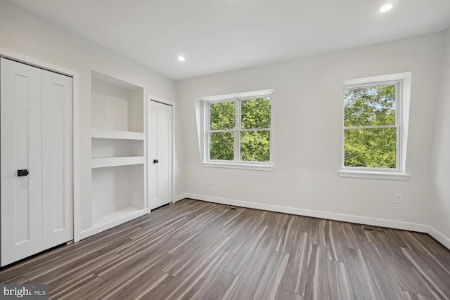 1850 Ingleside Ter NW Unit 2, Washington, DC 20010 - unfurnished bedroom with baseboards, multiple windows, dark wood-style flooring, two closets, and recessed lighting