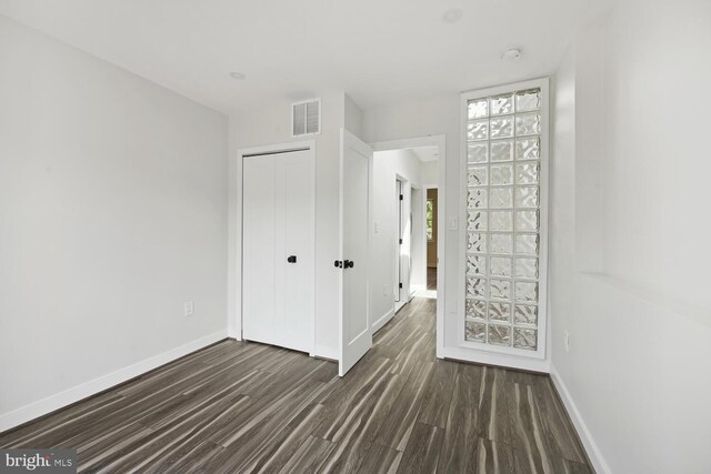 1850 Ingleside Ter NW Unit 2, Washington, DC 20010 - unfurnished bedroom with baseboards, dark wood-style flooring, and a closet