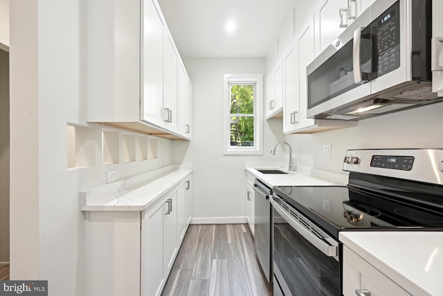 1850 Ingleside Ter NW Unit 2, Washington, DC 20010 - kitchen featuring stainless steel appliances, a sink, white cabinets, light wood finished floors, and baseboards