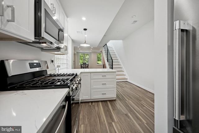1850 Ingleside Ter NW Unit 2, Washington, DC 20010 - kitchen featuring appliances with stainless steel finishes, dark wood-type flooring, white cabinets, a peninsula, and recessed lighting