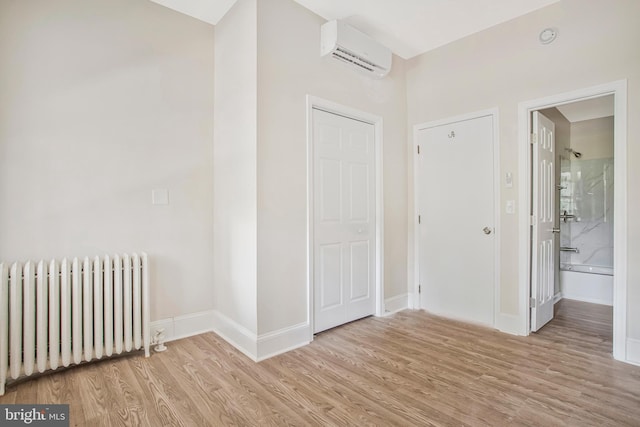 1003 Walnut Ave, Baltimore, MD 21229 - entryway with radiator, a wall mounted air conditioner, light wood-type flooring, and baseboards