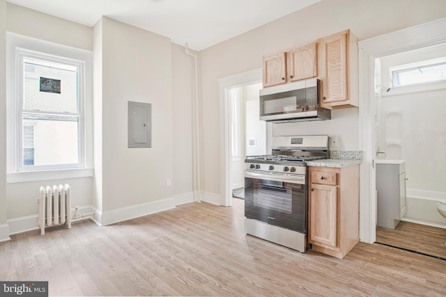 1003 Walnut Ave, Baltimore, MD 21229 - kitchen with stainless steel appliances, radiator, light brown cabinets, electric panel, and light wood finished floors