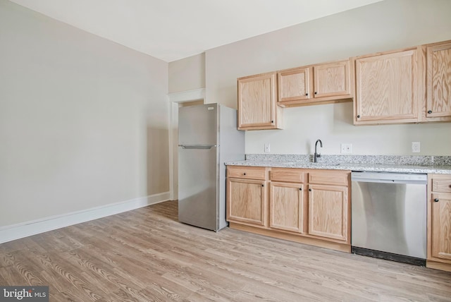 1003 Walnut Ave, Baltimore, MD 21229 - kitchen with appliances with stainless steel finishes, light brown cabinets, a sink, light wood-style flooring, and light stone counters