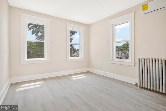 1003 Walnut Ave, Baltimore, MD 21229 - spare room with a wall unit AC, radiator heating unit, wood finished floors, and baseboards