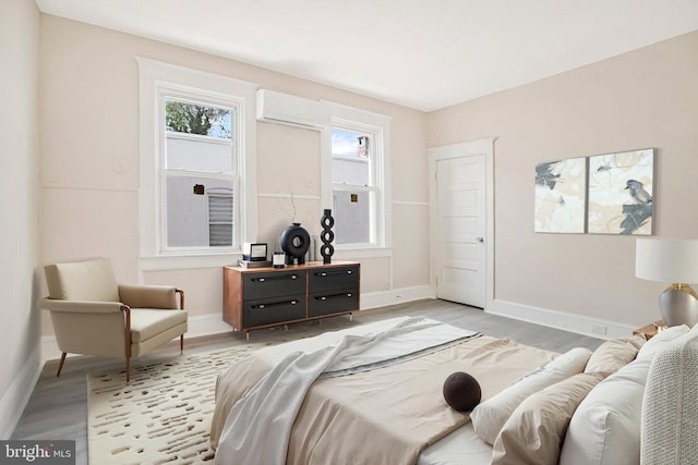 1003 Walnut Ave, Baltimore, MD 21229 - bedroom with a wall mounted AC, light wood-type flooring, and baseboards