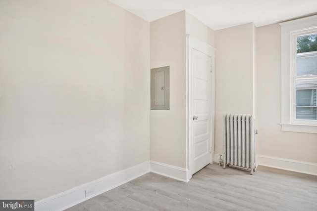 1003 Walnut Ave, Baltimore, MD 21229 - empty room with radiator heating unit, electric panel, light wood finished floors, and baseboards
