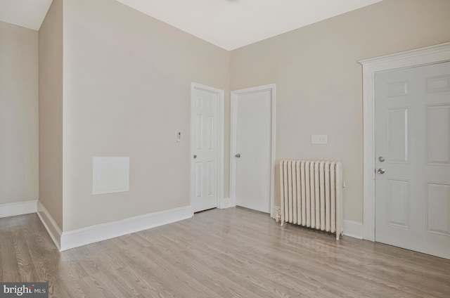 1003 Walnut Ave, Baltimore, MD 21229 - empty room featuring radiator heating unit, light wood finished floors, and baseboards