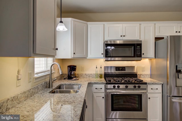 605 Byler Cir, Lebanon, PA 17042 - kitchen with appliances with stainless steel finishes, a sink, white cabinetry, light stone counters, and decorative light fixtures