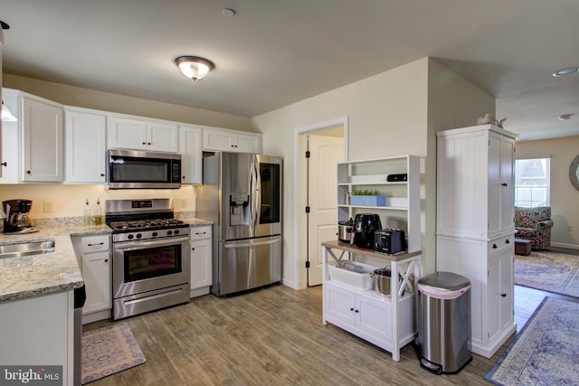 605 Byler Cir, Lebanon, PA 17042 - kitchen featuring stainless steel appliances, white cabinetry, wood finished floors, light stone counters, and a sink