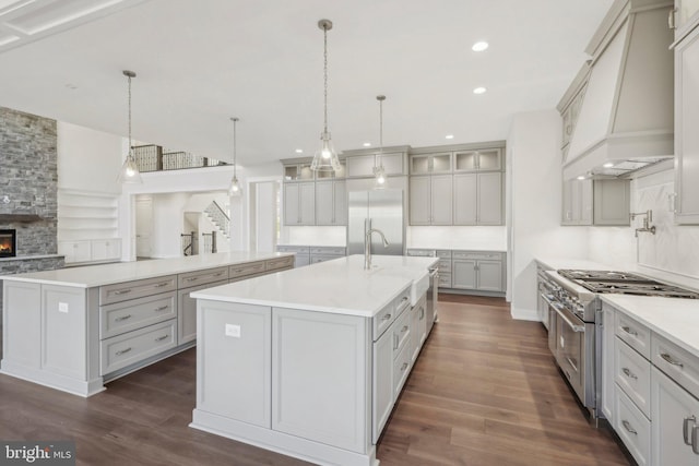 545 Webb Rd # Dd, Chadds Ford, PA 19317 - kitchen with premium appliances, custom exhaust hood, a center island with sink, dark wood-style floors, and glass insert cabinets