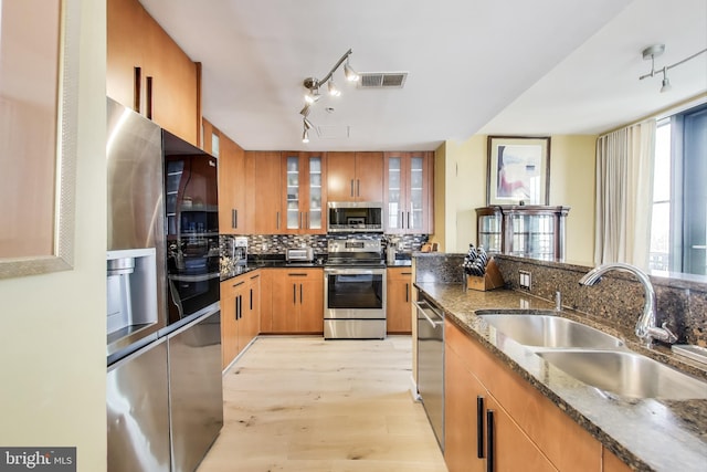 910 M St NW Unit 1022, Washington, DC 20001 - kitchen with appliances with stainless steel finishes, track lighting, backsplash, light wood-style flooring, and dark stone counters