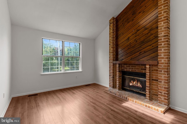 1040 Muscovy Ln, Bensalem, PA 19020 - unfurnished living room featuring wood finished floors, a brick fireplace, lofted ceiling, and baseboards
