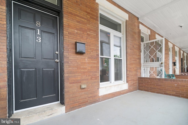 813 N Linwood, Baltimore, MD 21205 - doorway to property featuring covered porch and brick siding