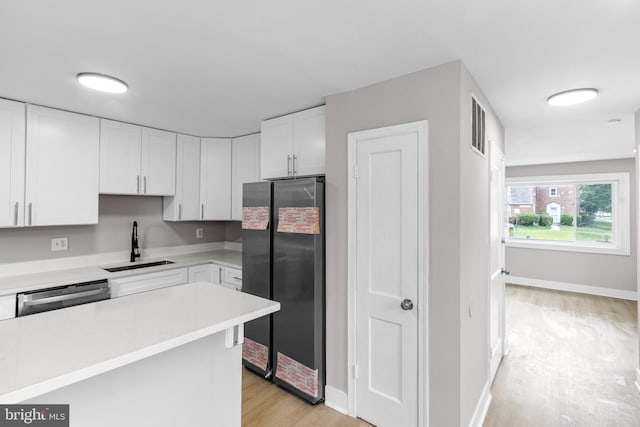 2723 Keating St, Temple Hills, MD 20748 - kitchen with stainless steel appliances, a sink, light wood-style flooring, white cabinetry, and light countertops