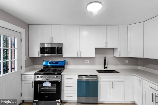 2723 Keating St, Temple Hills, MD 20748 - kitchen featuring appliances with stainless steel finishes, a sink, white cabinets, and light countertops