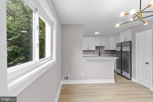 2723 Keating St, Temple Hills, MD 20748 - kitchen with freestanding refrigerator, light countertops, white cabinets, and light wood finished floors