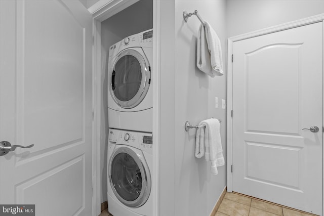 1451 Belmont St NW Unit 321, Washington, DC 20009 - laundry room with stacked washer and clothes dryer and light tile patterned floors