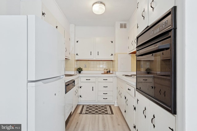 1900 John F Kennedy Blvd Unit 924, Philadelphia, PA 19103 - kitchen featuring freestanding refrigerator, black oven, decorative backsplash, and white cabinets