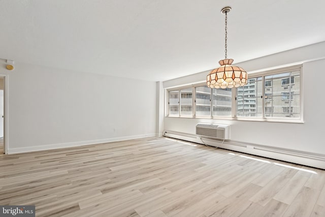 1900 John F Kennedy Blvd Unit 924, Philadelphia, PA 19103 - unfurnished dining area featuring a baseboard heating unit, light wood finished floors, and a wall mounted air conditioner